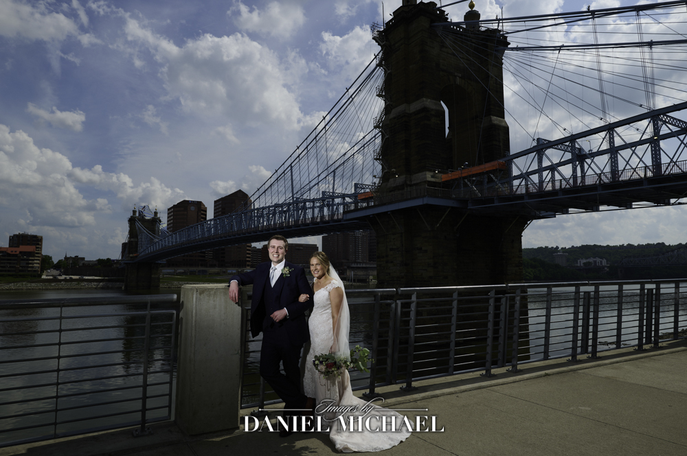 Couple in front of bridge and river