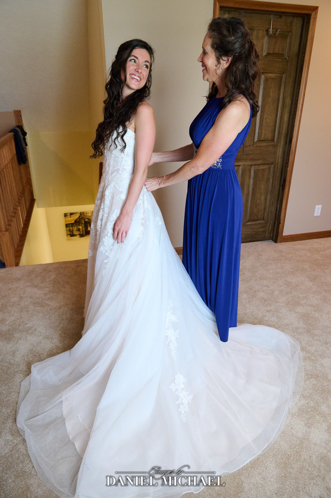 Mom helping Bride into Dress
