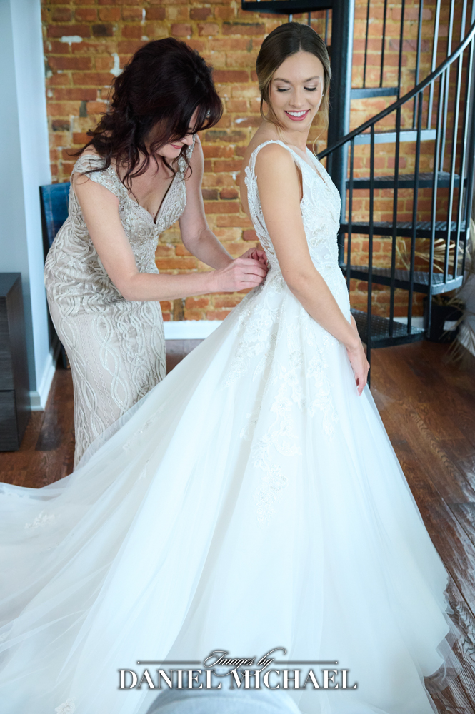Mother helping bride into dress photo